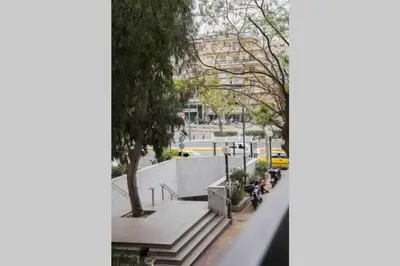 a group of people riding a motorcycle down a city street at 7 Steps Apartment Metro Syggrou Fix near Acropolis in Athens
