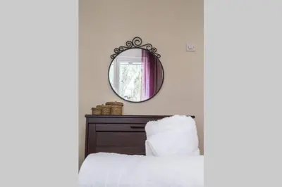 a bedroom with a mirror above a bed at 7 Steps Apartment Metro Syggrou Fix near Acropolis in Athens