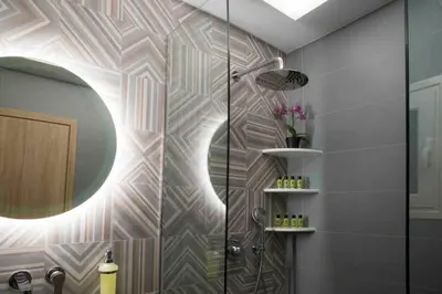 a bathroom with a shower with a mirror and a sink at 7 Steps Apartment Metro Syggrou Fix near Acropolis in Athens