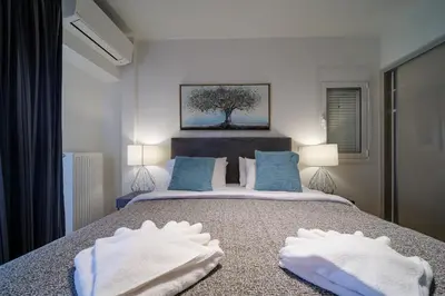 a bedroom with a bed with two white towels on it at Faliro Lux Apartment By The Sea VIPGreece in Athens