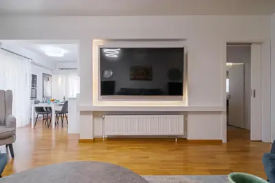 a living room with a large flat screen tv on a wall at Faliro Lux Apartment By The Sea VIPGreece in Athens