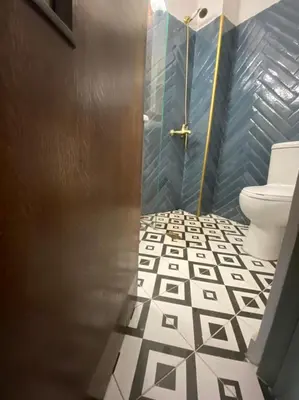 a bathroom with a toilet and a tile floor at Mosaics aprtm in Monastiraki with Acropolis view in Athens