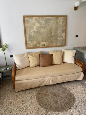 a couch in a living room with a map on the wall at Mosaics aprtm in Monastiraki with Acropolis view in Athens