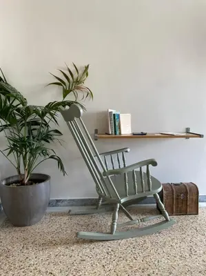a green rocking chair sitting next to a potted plant at Mosaics aprtm in Monastiraki with Acropolis view in Athens