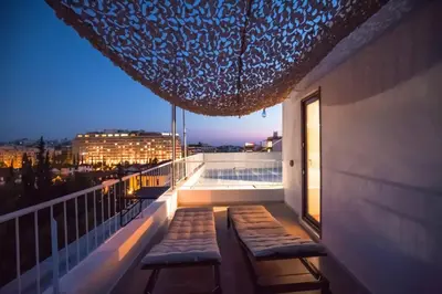 a balcony with two benches and a pool on a building at Diamond in the Sky in Athens