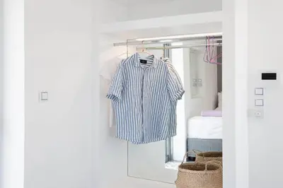 a blue shirt hanging on a rack in a bedroom at Diamond in the Sky in Athens