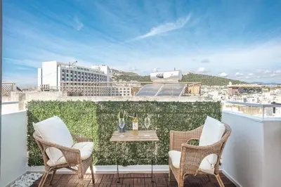 a patio with chairs and a table on a balcony at Diamond in the Sky in Athens