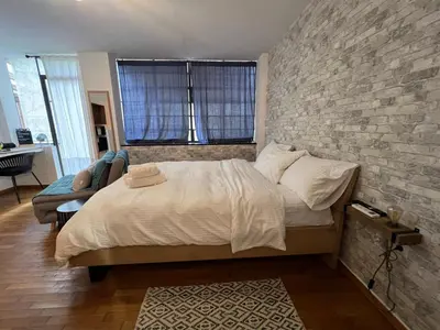 a bedroom with a bed and a brick wall at Studio Mavili in Athens