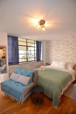 a bedroom with a large bed and a chair at Studio Mavili in Athens