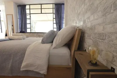 a bedroom with a bed with pillows and a brick wall at Studio Mavili in Athens