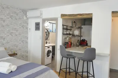 a bedroom with a bed and a kitchen with a sink at Studio Mavili in Athens