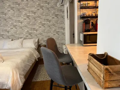 a bedroom with a bed and two chairs next to a desk at Studio Mavili in Athens