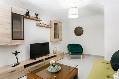 a living room with a television and a green chair at Plaka's Hyatt in Athens