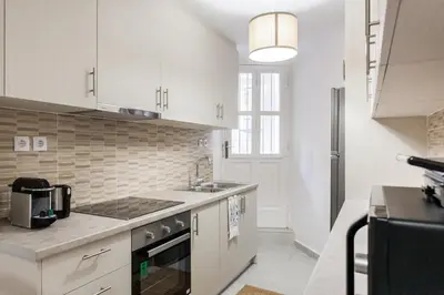 a kitchen with white cabinets and a sink at Plaka's Hyatt in Athens