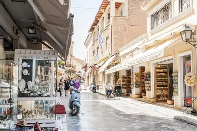 a street with shops and a scooter parked on a street at Plaka's Hyatt in Athens