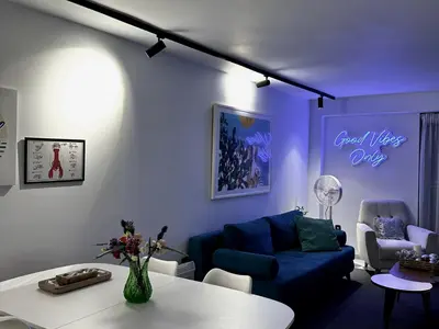 a living room with a blue couch and a table at Becool Apartment in Porto Rafti