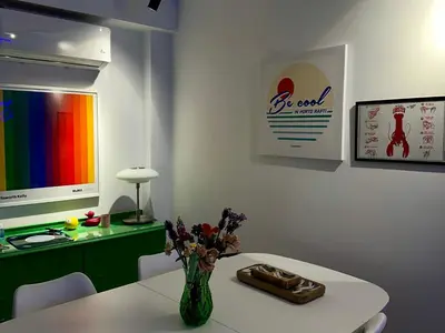 a room with a white table with a vase of flowers at Becool Apartment in Porto Rafti