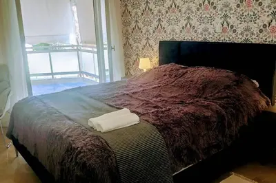 a bed with a pair of white towels on it at Luxurious apartment close to the beach and airport in Porto Rafti
