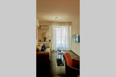 a living room with a couch and a table at Luxurious apartment close to the beach and airport in Porto Rafti
