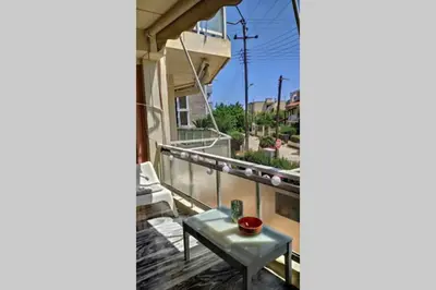 a balcony with a table and a view of a street at Luxurious apartment close to the beach and airport in Porto Rafti