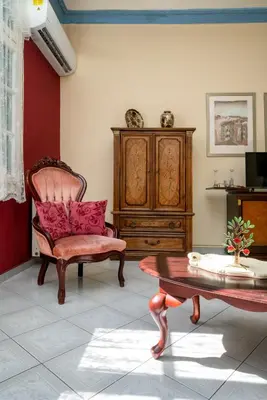 a living room with a chair and a table at ViLLA127 in Athens