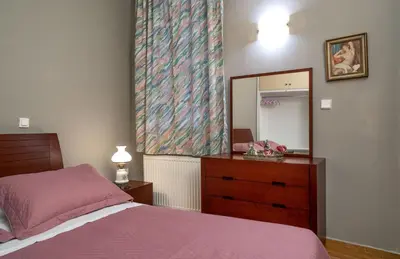 a bedroom with a bed and a dresser and a mirror at ViLLA127 in Athens