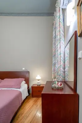 a bedroom with a bed and a table with a night stand at ViLLA127 in Athens