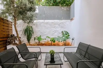 a patio with chairs and a wall with plants at Place to be Athens apartment in Athens