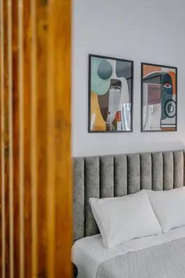 a bedroom with a bed with three pictures on the wall at Place to be Athens apartment in Athens