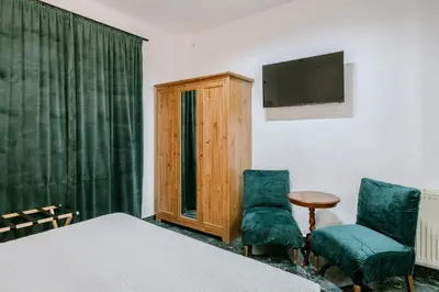 a bedroom with a bed and two chairs and a television at Place to be Athens apartment in Athens
