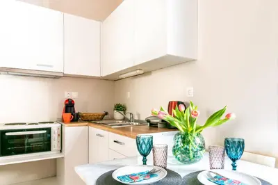 a kitchen with white cabinets and a table with plates at Place to be Athens apartment in Athens