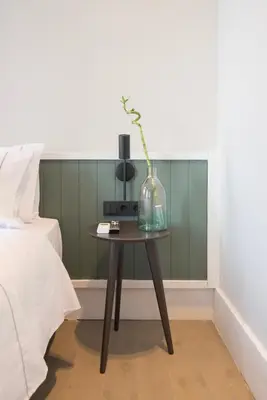 a table with a vase on it next to a bed at Acron Athens in Athens