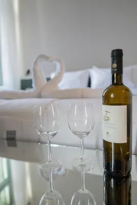 a bottle of wine and two wine glasses on a table at Acron Athens in Athens