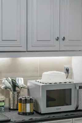 a kitchen counter with a microwave on a counter top at Cuervo Poolside Villa in Kalívia Thorikoú