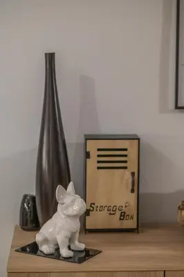 a statue of a pig sitting on a table next to a box at Cuervo Poolside Villa in Kalívia Thorikoú