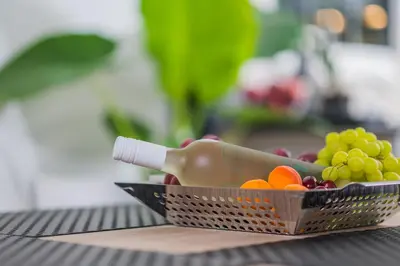 a basket of fruit with a bottle in it at Cuervo Poolside Villa in Kalívia Thorikoú