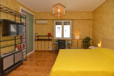 a bedroom with a yellow bed and a flat screen tv at Athens Stylish studio in front of Syntagma metro stop for 2 in Athens