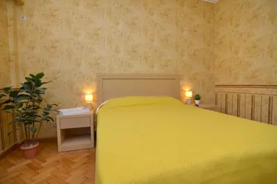 a bedroom with a yellow bed and two lights at Athens Stylish studio in front of Syntagma metro stop for 2 in Athens