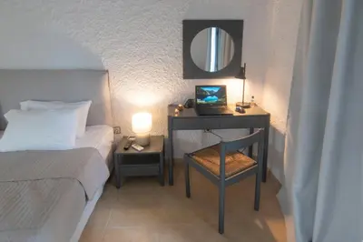 a bedroom with a bed and a desk with a mirror at Apollo Resort in Agia Marina Aegina