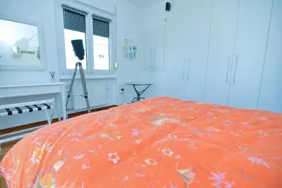 a bedroom with a bed with an orange comforter at Athens Stylish top floor apartment Syntagma metro in Athens