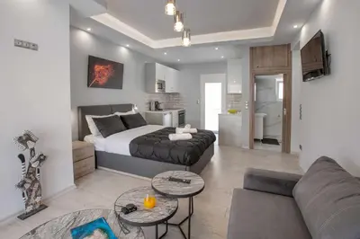 a bedroom with a bed and a living room at Studio penthouse near Acropolis Museum by GHH in Athens