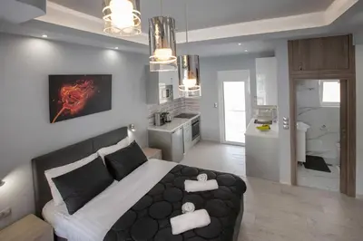 a bedroom with a large bed and a kitchen at Studio penthouse near Acropolis Museum by GHH in Athens