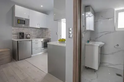 a white kitchen with a sink and a counter top at Studio penthouse near Acropolis Museum by GHH in Athens