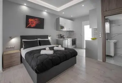 a bedroom with a large bed and a kitchen at Studio penthouse near Acropolis Museum by GHH in Athens