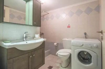 a bathroom with a washing machine and a sink at Stylish apt in the Historic heart of the city in Athens
