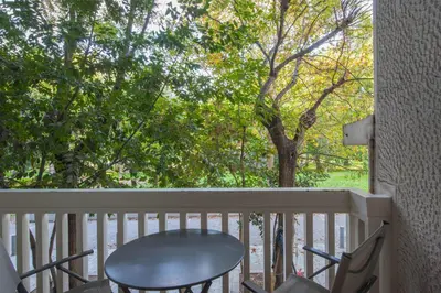 a table and chairs on a porch with a tree at Stylish apt in the Historic heart of the city in Athens