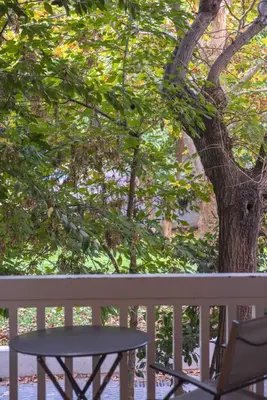 a table and a chair next to a tree at Stylish apt in the Historic heart of the city in Athens