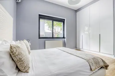 a bedroom with a large white bed and a window at Spacious flat with courtyard in Peristeri! in Athens