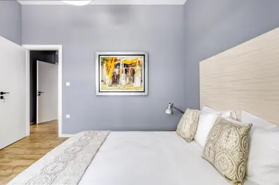 a bedroom with a white bed and a painting on the wall at Spacious flat with courtyard in Peristeri! in Athens