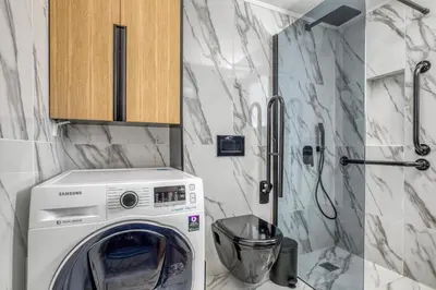 a washing machine in a bathroom with a shower at Spacious flat with courtyard in Peristeri! in Athens